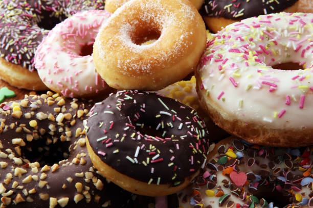 istock assorted donuts with chocolate frosted, pink glazed and sprinkles donuts. 924850380