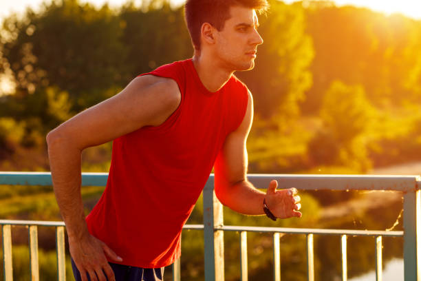 istock Young man running on bridge at sunset. 924853240