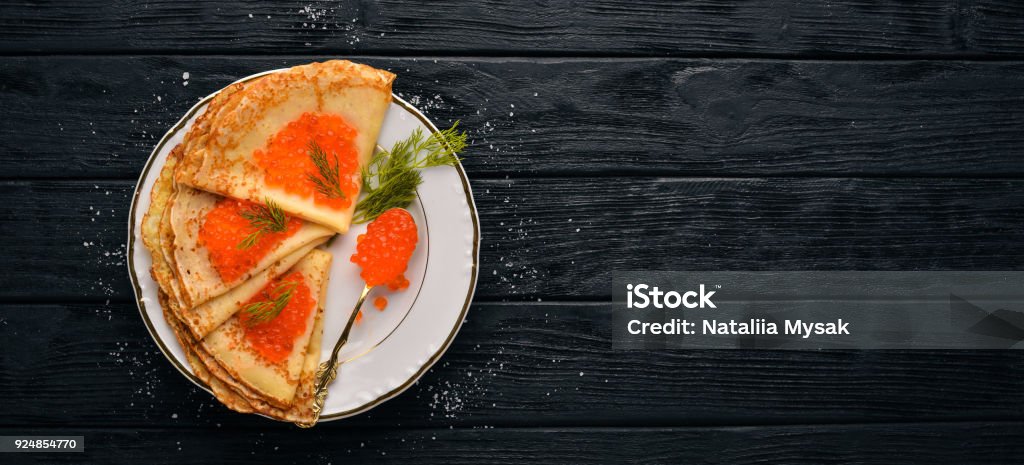 Pfannkuchen mit rotem Kaviar auf einem Teller. Auf einem hölzernen Hintergrund. Ansicht von oben. Freiraum für Text. - Lizenzfrei Backen Stock-Foto