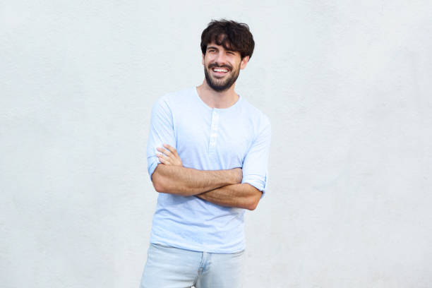 istock happy young man with beard smiling by wall 924861444