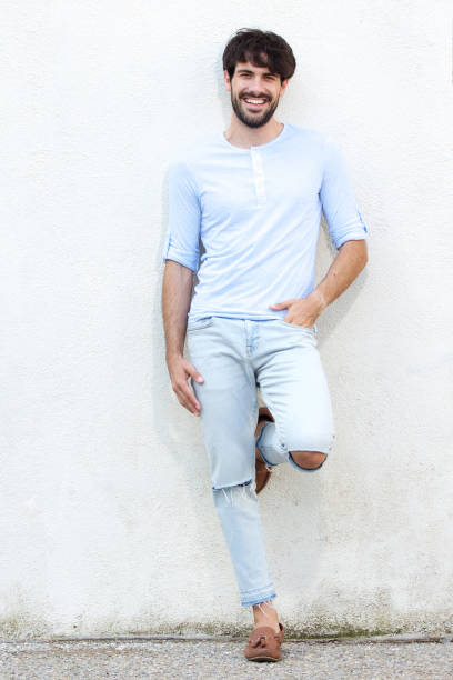 istock Full body handsome young man leaning against white wall and smiling 924861454