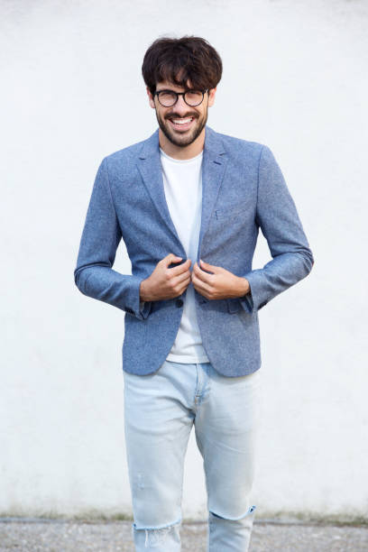 istock happy young man with glasses standing abasing white wall 924861496