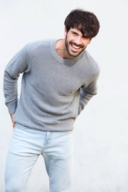 istock handsome young man with beard laughing against white wall 924861508