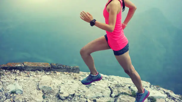 Photo of sporty woman trail runner running at great wall on the top of mountain