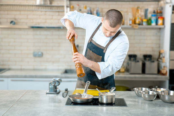 istock chef cook standing and cooking in frying pan on the kitchen 924862362