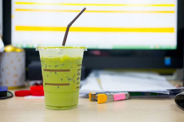 Iced matcha green tea with straw put on table in office