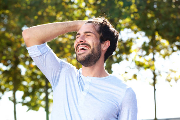 istock happy young man smiling outdoors with hand in hair 924867038