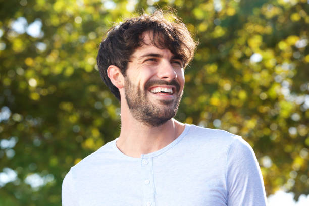 istock Close up handsome young man with beard smiling outdoors 924867048