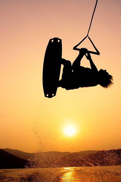 Wakeboarder silhouette mit dem Flugzeug in der Luft bei Sonnenuntergang – Foto
