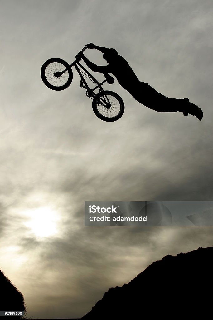 BMX ciclista jumper realiza um truque de Super-homem - Foto de stock de Ciclismo BMX royalty-free