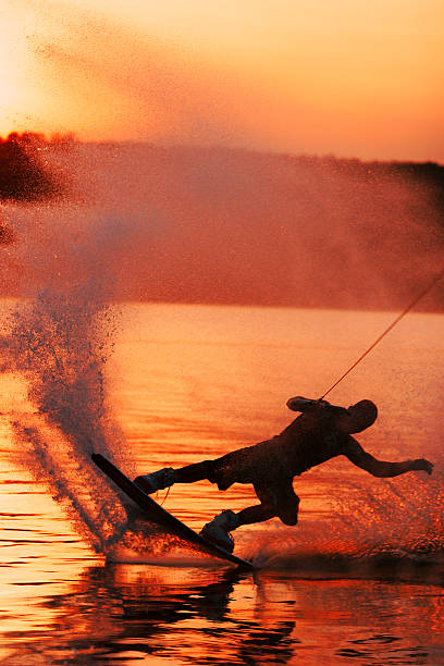 wakeboarder раздвижные закате - wakeboarding waterskiing water ski sunset стоковые фото и изображения