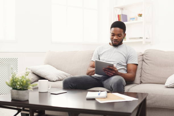 istock Young man at home messaging online on tablet 924901160