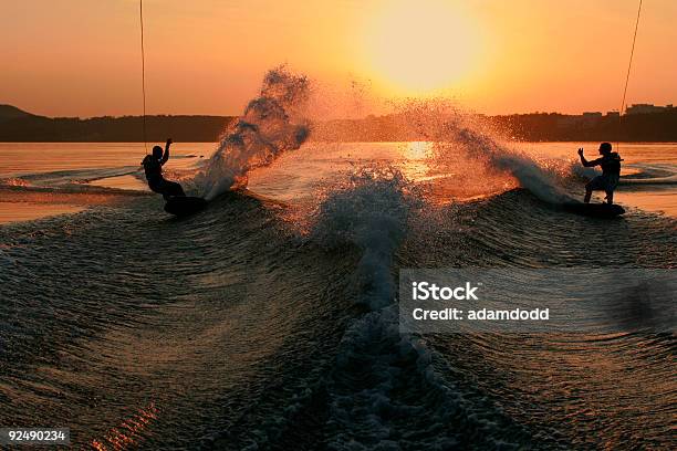 Dos Wakeboarders Cortar La Vista A La Puesta De Sol Foto de stock y más banco de imágenes de Esquí acuático