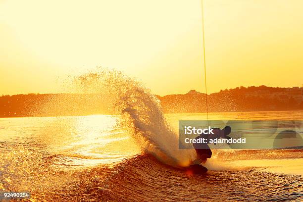 Wakeboarder Slashes Wake On Heel Side During Sunset Stock Photo - Download Image Now