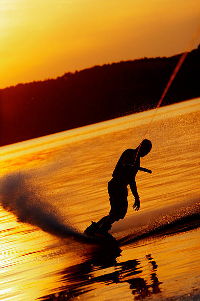 istock Wakeboarder slides on glassy water at sunset 92490260