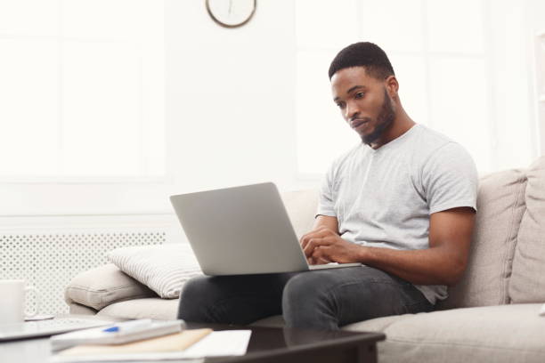 istock Young man at home messaging online on laptop 924904020