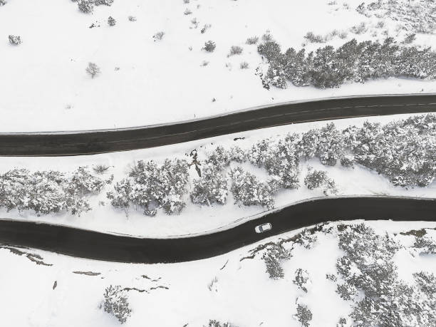 istock Car driving in mountain road in winter Drone view 924907686