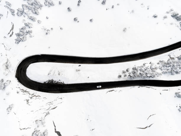 Car driving in mountain road in winter Drone view