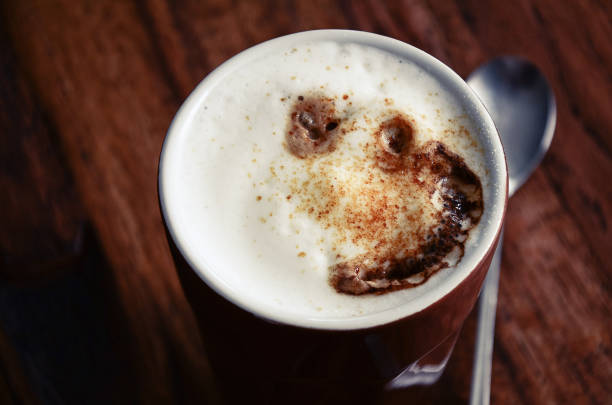 latte macchiato café tasse avec une cuillère sur fond marron foncé. gros plan, horizontal. - latte machiatto photos et images de collection