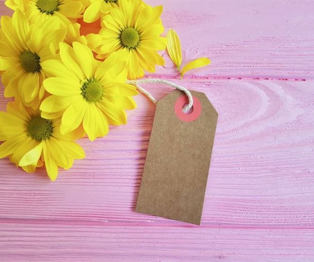 istock yellow chrysanthemum tag on a pink wooden background 924915032