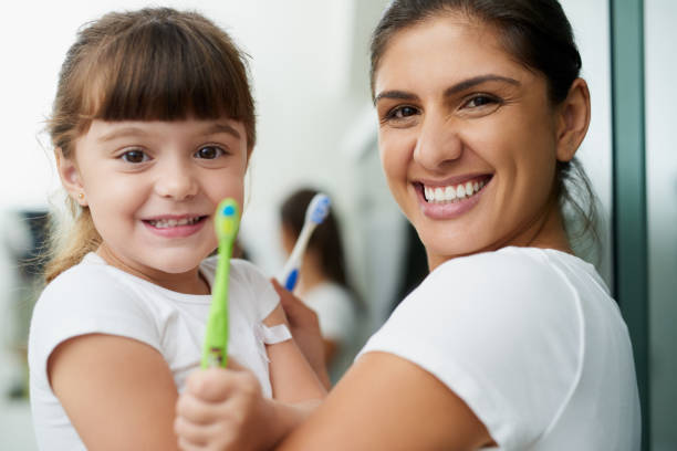 Brush twice daily because what's a home without the smiles? Portrait of a mother and daughter brushing their teeth together in the bathroom at home brushing teeth stock pictures, royalty-free photos & images