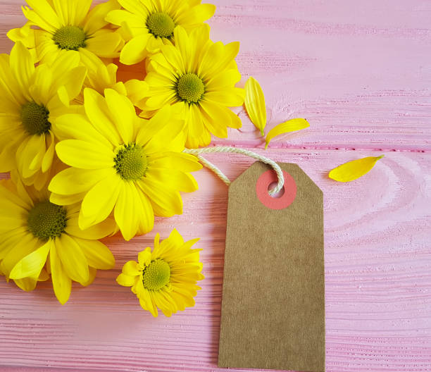 istock yellow chrysanthemum tag on a pink wooden background 924916120