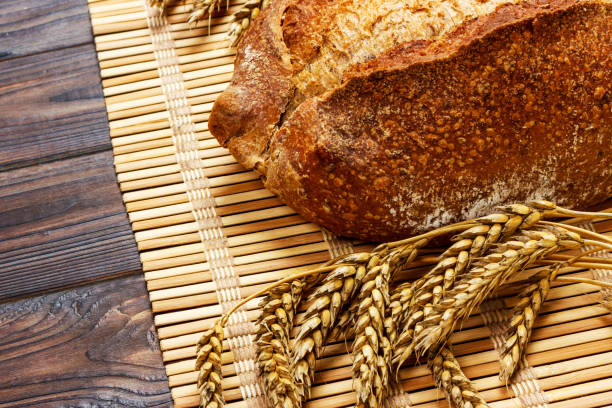 istock Fresh Homemade Whole Bread with wheat on a wooden Background 924918340