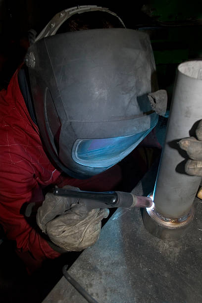 istock Man wearing welding mask welding a tube 92491848