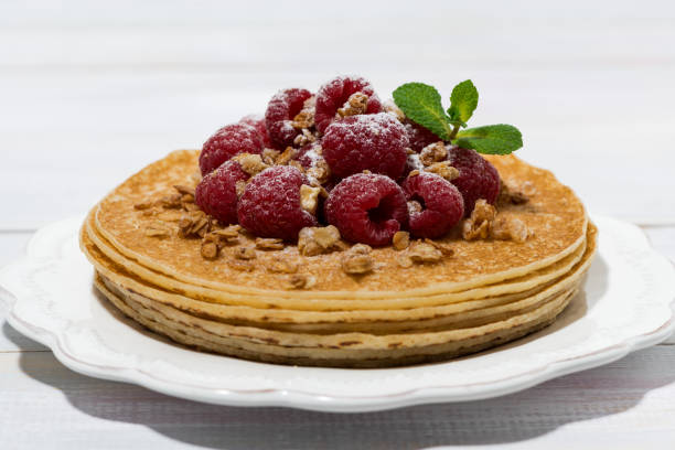 istock traditional thin pancakes with fresh raspberries on wooden table 924920036