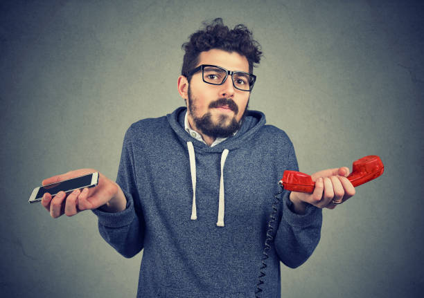 istock Young man looking puzzled about old fashioned and contemporary gadgets. 924920088