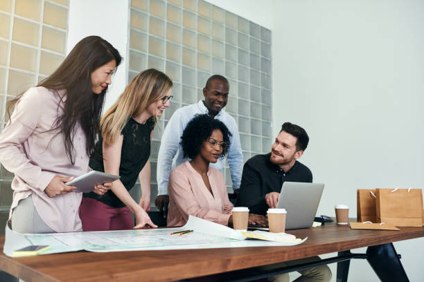 istock Group of smiling businesspeople working together around an office table 924923050