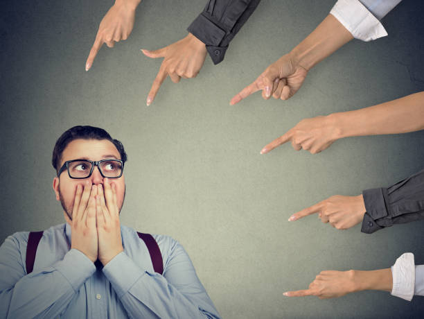 hombre ansioso juzgado por diferentes personas. concepto de acusación de persona culpable - embarrassment men business guilt fotografías e imágenes de stock