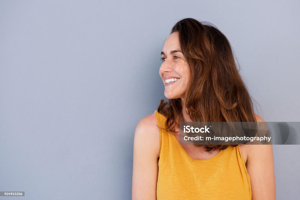 Close up beautiful older woman smiling against gray wall Close up portrait of beautiful older woman smiling against gray wall 35-39 Years Stock Photo