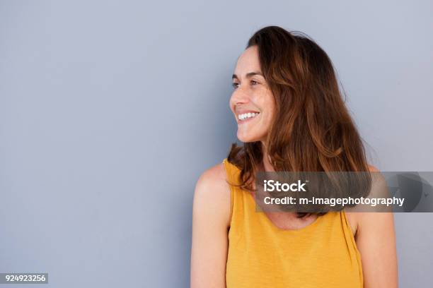 Close Up Beautiful Older Woman Smiling Against Gray Wall Stock Photo - Download Image Now