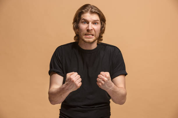 istock The young emotional angry man screaming on pastel studio background 924926384