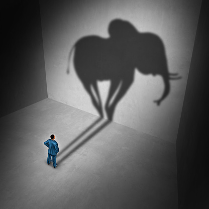 Elephant in the room idiom and metaphor problem concept as a person casting a shadow shaped as a huge mammal as a psychology symbol for repression in a 3D illustration style.