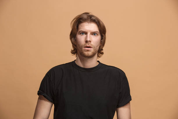 istock The young attractive man looking suprised isolated on pastel 924927722