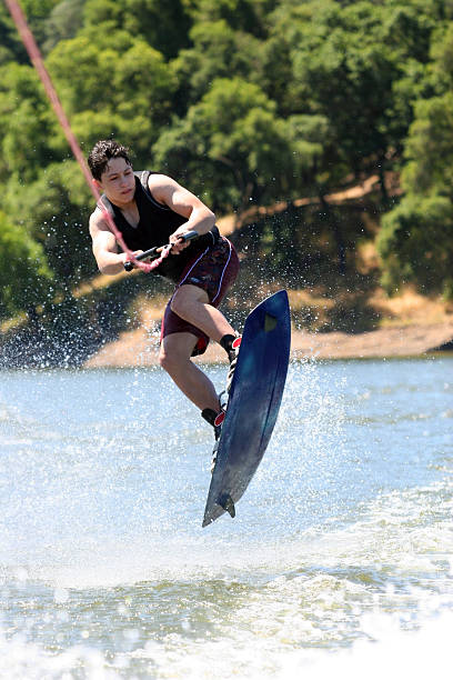 wakeboarding - life jacket little boys lake jumping foto e immagini stock