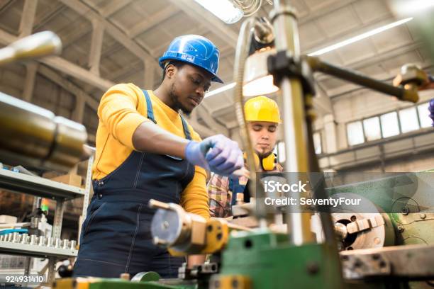 Foto de Torneiros Mecânicos Concentrados No Trabalho e mais fotos de stock de Manufaturar - Manufaturar, Ocupação, Fábrica