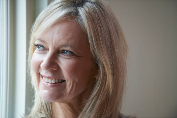 istock Smiling Mature Woman Standing Next To Window 924931734