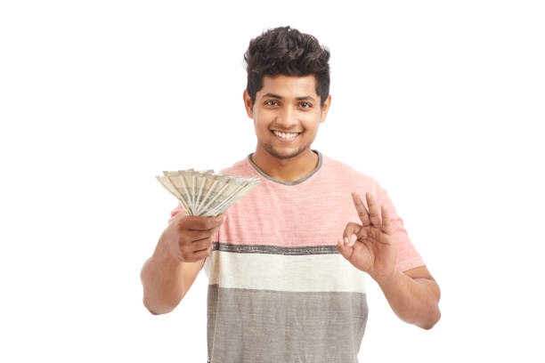 istock Cheerful young man offering Indian rupees 924935660