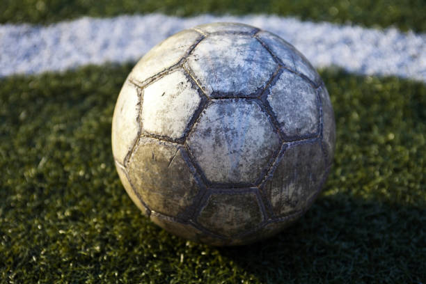 istock Old leather soccer ball on a green lawn 924935818