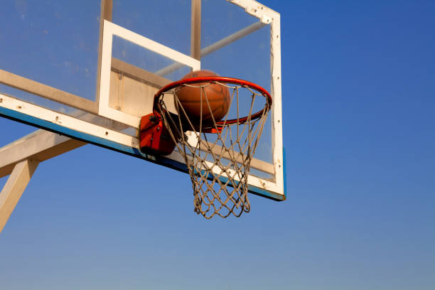 istock Basketball hoop on open court on blue sky background 924938192