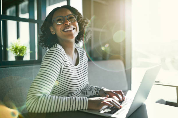 istock Young African woman laughing while working online with a laptop 924939870