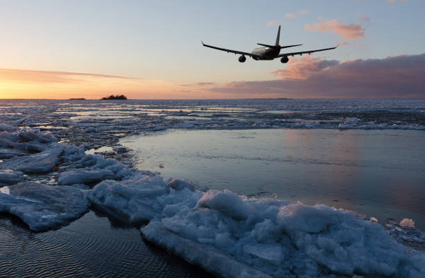 istock Airplane flying above the sea in sky with clouds at sunset time 924942048