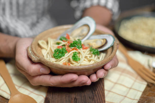 istock Handsome bearded cheef cook prepairing spaghetti on a kitchen, Chef cooks meal 924944336