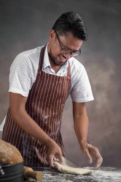istock Chef hipster stylish kneads dough for bread on wooden board 924944354