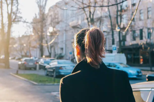 Photo of Slender brunette girl in black coat walking through the city