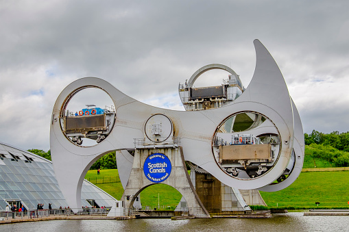 Tourists enjoying a tour on the narrow boats at the Falkirk Wheel, a rotating boat lift connecting the Forth and Clyde Canal with the Union Canal. The engineering work opened in 2002, reconnecting the two canals for the first time since the 1930s.