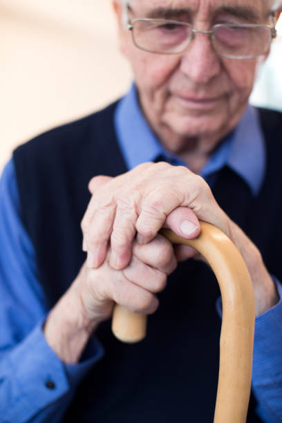 肩コリを持って椅子に座っている年配の男性を悲しい - human hand aging process senior adult cane ストックフォトと画像